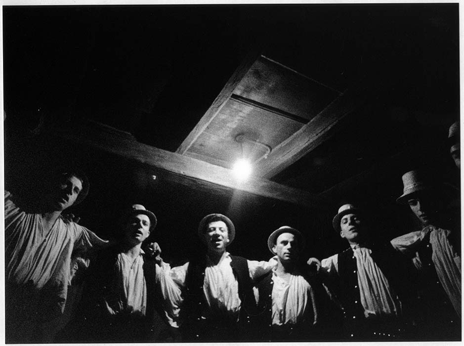 Young men sing in semi-circlular formation; 1970
